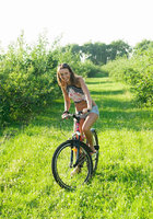 Спортивная мастерица заехала в зеленый сад на велосипеде 1 фотография