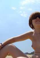 Туристка сидит на пляже топлесс 7 фото