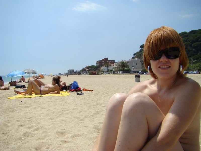 Туристка сидит на пляже топлесс 5 фотография