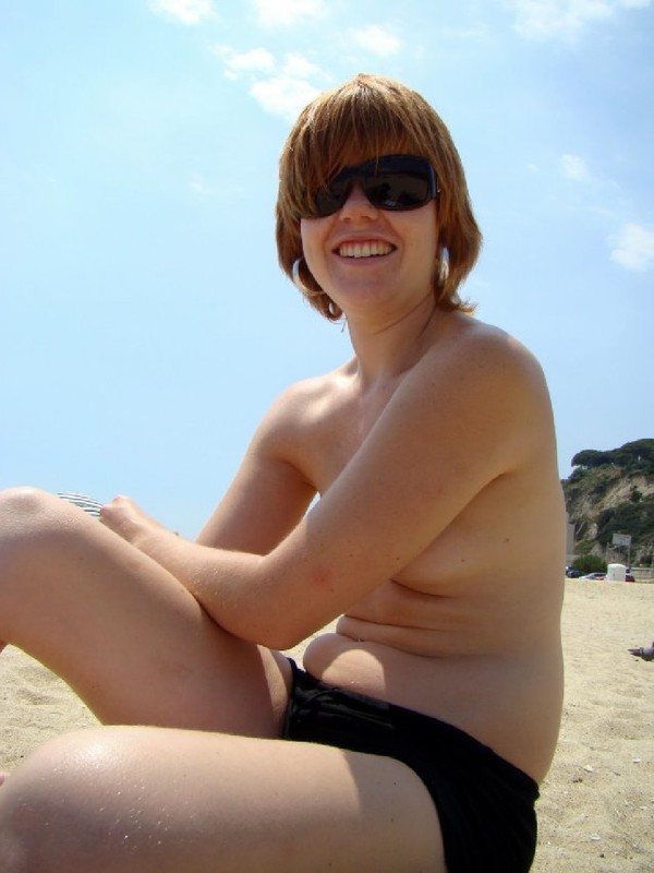 Туристка сидит на пляже топлесс 6 фотография