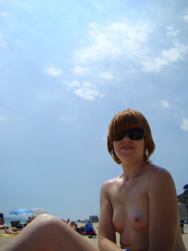 Туристка сидит на пляже топлесс 8 фотография