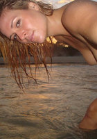 Шалунья лежит спиной на песке во время заката 13 фотография