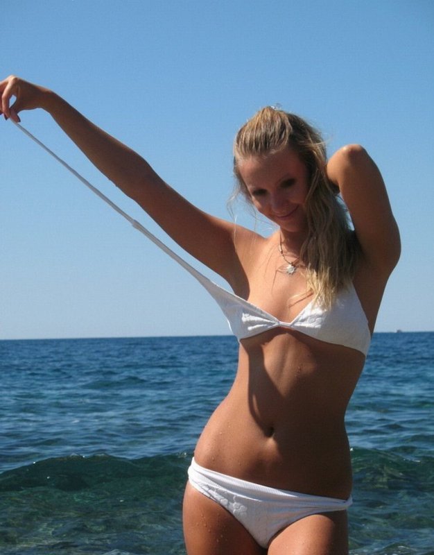 Пошлая блондинка развязывает белые купальник на море 3 фотография