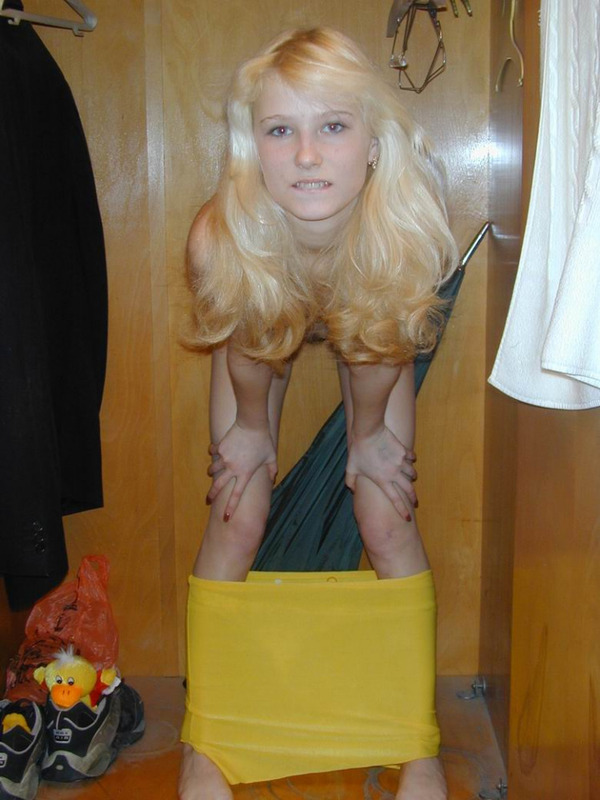 Худенькая молодуха снимает желтые шортики на фоне шкафа 12 фотография