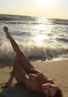 Голая бабенка встречает закат на песчаном берегу 1 фото