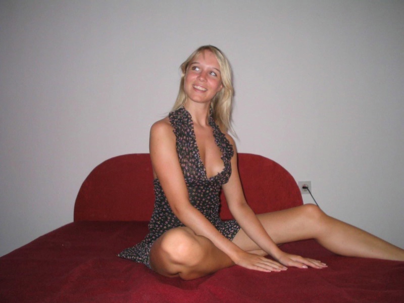 Молодая блондинка расположилась на красной кровати 3 фотография