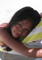 Смазливая азиатка стоит без лифчика на пляже 5 фотография