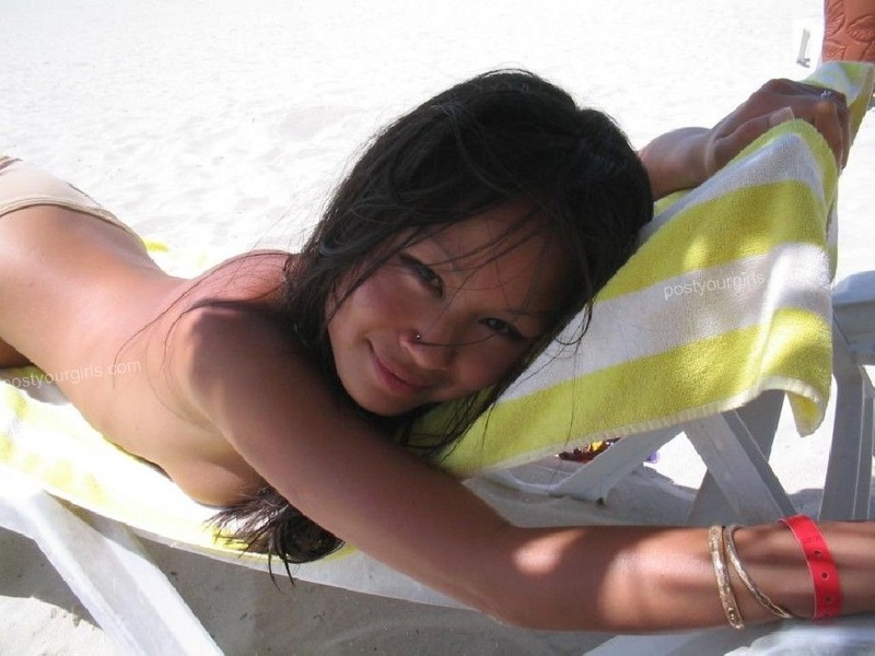 Смазливая азиатка стоит без лифчика на пляже 5 фотография