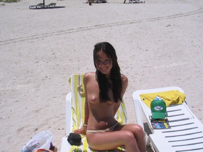 Смазливая азиатка стоит без лифчика на пляже 4 фотография