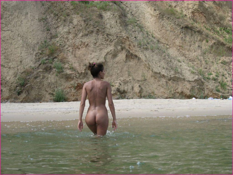 На морском побережья Светлана поливает голую грудь из бутылки 2 фотография