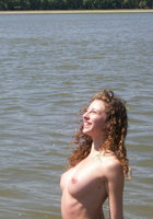 Молодая кудряшка купается в реке в одних трусах 12 фотография