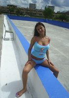 Молодая красотка сняла с себя голубой топик возле пустого бассейна 2 фото