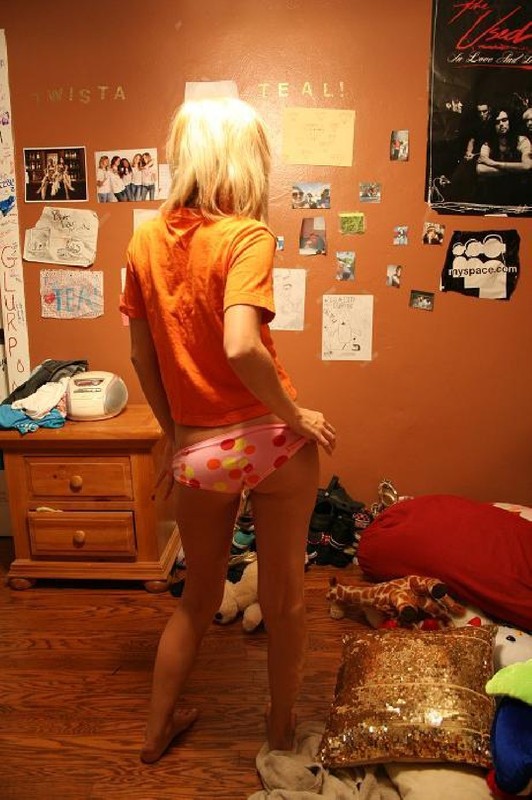 Сексапильная блонди стоит в спальне лишь в трусах 13 фотография