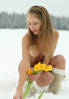 Голая снегурочка сидит с цветами на снегу 3 фотография