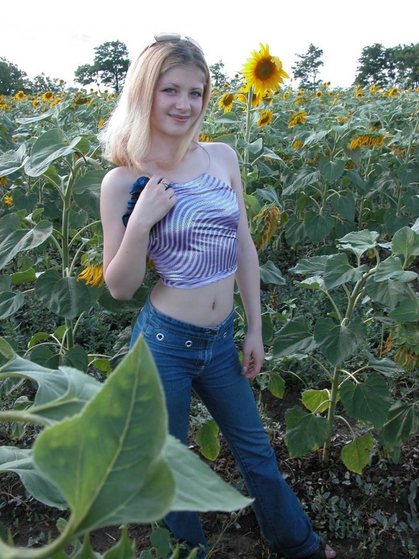 Молодая блонда раздевается среди подсолнухов 3 фотография