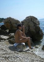 Темноволосая жена голая бродит по прибрежным скалам 16 фотография
