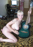 Голая музыкантка позирует с гитарой в спальне 5 фото