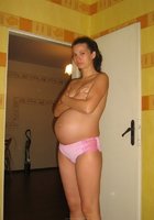 Даже беременность не мешает брюнетке оставаться в одних трусах 11 фотография
