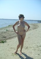 Зрелая телка сексуально позирует на нудистском пляже 18 фото