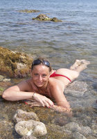 Светлана расставила ноги на камнях возле моря 5 фотография