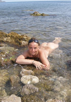 Светлана расставила ноги на камнях возле моря 7 фотография