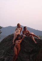 Три голые женщины залезли на большой камень 13 фотография