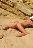 Голая дама проводит лето валяясь в песке 1 фото