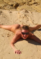 Голая дама проводит лето валяясь в песке 11 фото