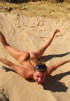 Голая дама проводит лето валяясь в песке 13 фото
