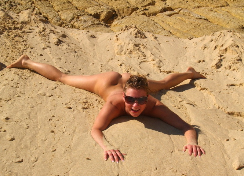 Голая дама проводит лето валяясь в песке 11 фотография