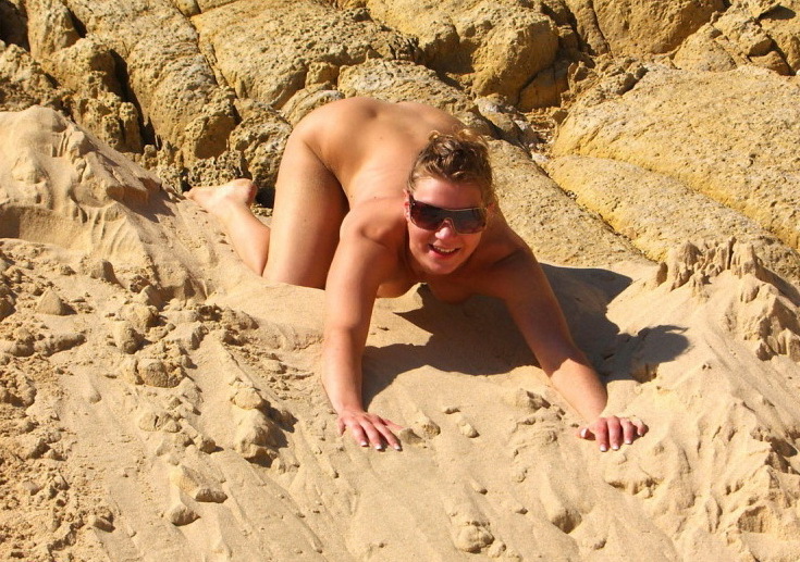Голая дама проводит лето валяясь в песке 9 фотография