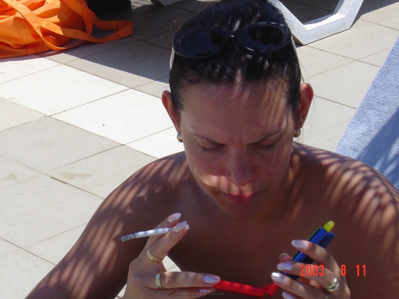 Взрослая брюнетка отдыхает в бассейне топлес 4 фотография