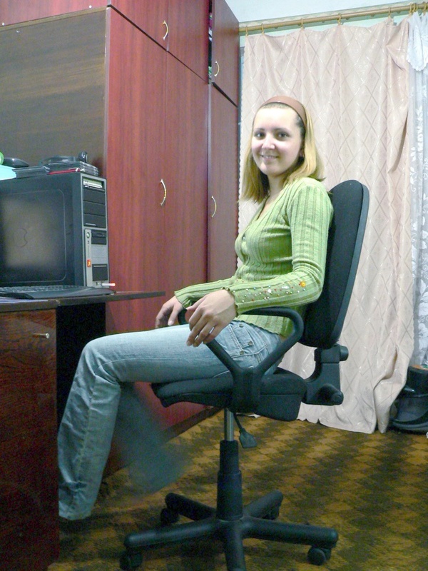 Милашка раздевается сидя на компьютерном кресле 1 фотография
