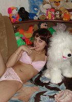 Развратная мамочка показывает сиськи на диване в куче мягких игрушек 5 фотография