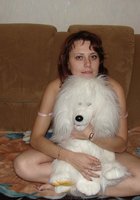 Развратная мамочка показывает сиськи на диване в куче мягких игрушек 6 фотография