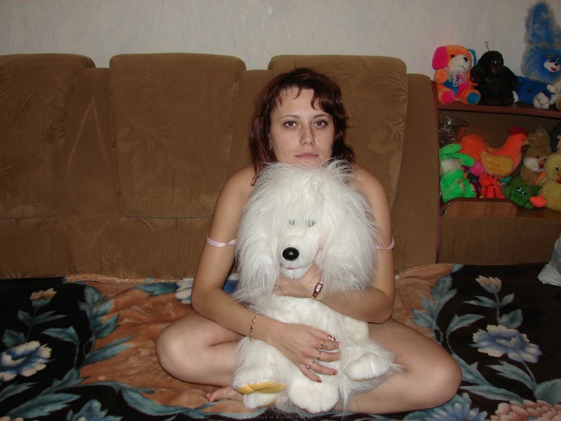 Развратная мамочка показывает сиськи на диване в куче мягких игрушек 2 фотография