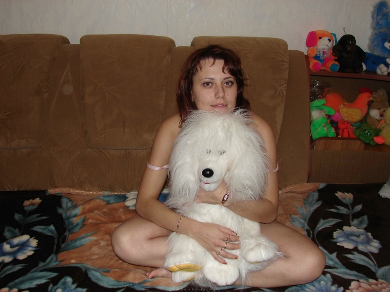 Развратная мамочка показывает сиськи на диване в куче мягких игрушек 6 фотография