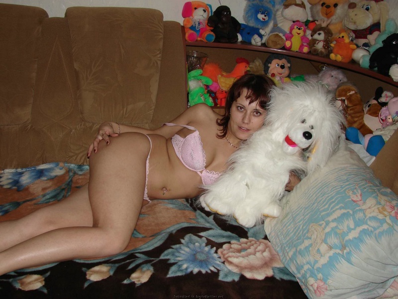 Развратная мамочка показывает сиськи на диване в куче мягких игрушек 3 фотография