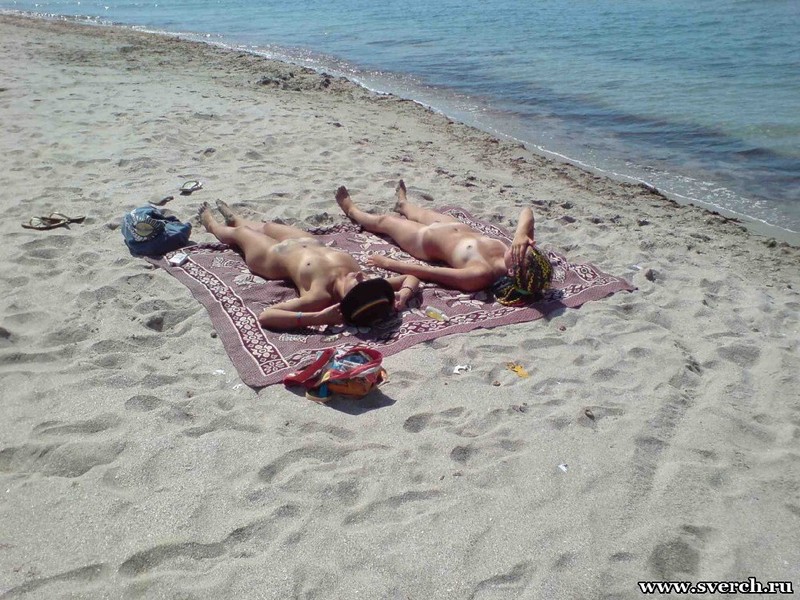 Две прошмандовки загорают голые на пляже 8 фотография