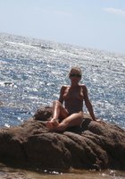 Загорелая тетка отдыхает на берегу моря в обнаженном виде 8 фото