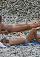Голые дамы лежат на галечном пляже 3 фотография