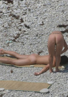 Голые дамы лежат на галечном пляже 10 фото