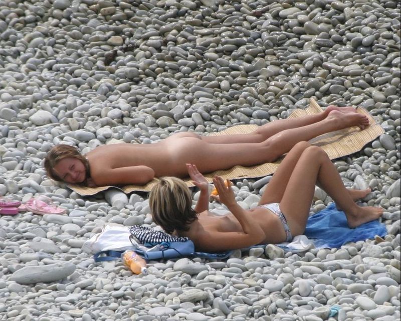 Голые дамы лежат на галечном пляже 4 фотография