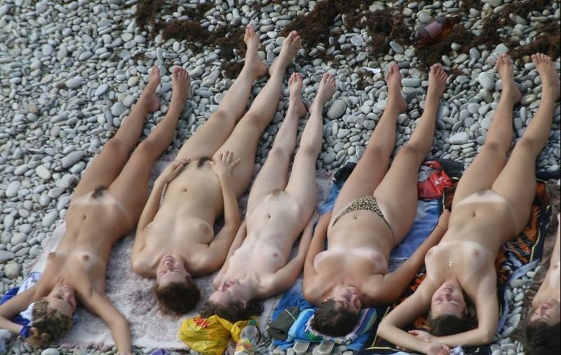Голые дамы лежат на галечном пляже 11 фотография