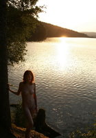 Симпатичная девчонка показывает молоденькое тело на берегу озера 6 фотография