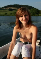 Симпатичная девчонка показывает молоденькое тело на берегу озера 2 фото