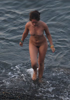 Голая нудистка выходит на берег из воды 2 фото