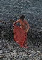 Голая нудистка выходит на берег из воды 5 фото