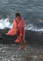 Голая нудистка выходит на берег из воды 9 фотография