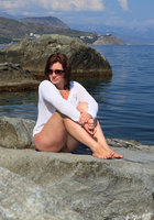 Мадам сидит голой жопой на прибрежных камнях 7 фото